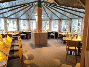 a dining room with tables and chairs and windows at Waldhotel Schäferberg in Espenau +38 photos