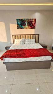 a bed in a bedroom with a painting on the wall at Anandam in Vrindāvan
