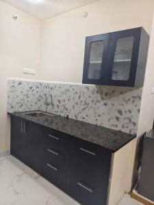 a kitchen with a black counter and a sink at Ramashraya in Indore