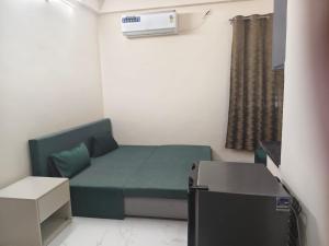 a small room with a green bed and a window at Ramashraya in Indore