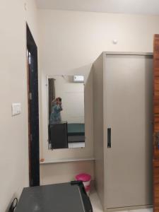 a person taking a picture of a mirror in a room at Ramashraya in Indore +6 photos