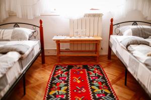 a room with two beds with a table in the middle at Domaćinstvo Koprivica in Zapolje