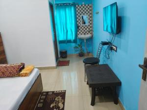 a room with a couch and a table and a sink at Ashirbad Lodge in Guwahati