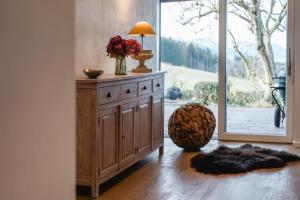 a room with a cabinet with a vase of flowers on it at PanoramaLodge Samerberg in Samerberg +31 photos