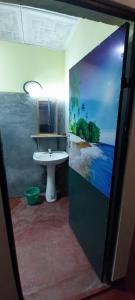 a bathroom with a sink and a painting of the ocean at Mango Mango in Tangalle