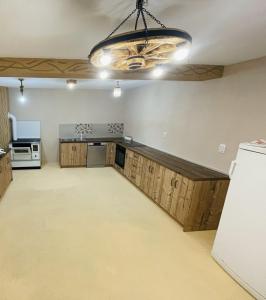 a large kitchen with wooden cabinets and a chandelier at Domaćinstvo Koprivica in Zapolje