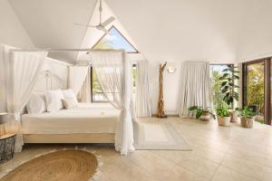 a bedroom with a white bed with a canopy at Sunset View by JuMa in Rivière Noire