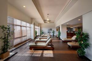a waiting room with couches and plants at Limak Lara Deluxe Hotel & Resort Antalya in Lara