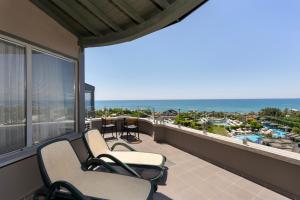 a balcony with chairs and a view of the ocean at Limak Lara Deluxe Hotel & Resort Antalya in Lara