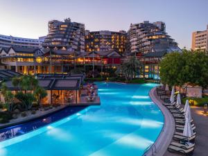 a swimming pool with buildings in the background at Limak Lara Deluxe Hotel & Resort Antalya in Lara
