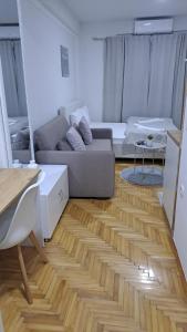 a living room with a couch and a wooden floor at Top Spot Studio in Ohrid