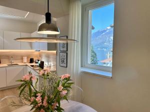 a kitchen with a window and a table with a vase of flowers at Contrada in Varenna