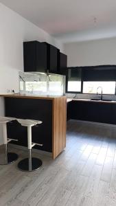a kitchen with a counter and a table and chairs at Résidence LE MÄYSA in Sada