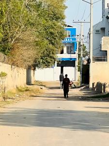 two people walking down a street at Hotel Marvi Multan in Multan