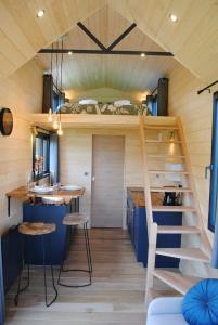 a tiny house with a bunk bed and a ladder at Tiny House - La P'tite Georgette in Canouville