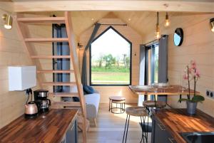 a tiny house with a staircase and a living room at Tiny House - La P'tite Georgette in Canouville