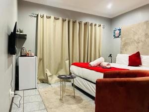 a small bedroom with a bed and a couch at De'Lush Oasis in Pretoria