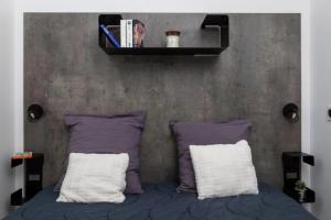a bed with two pillows and a shelf above it at ZEcamping 4 étoiles animé piscine couverte 1km plage fitness mobil-home TV in Saint-Jean-de-Monts