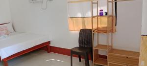 a small bedroom with a bed and a chair at Mangas Residents in El Nido +1 photo