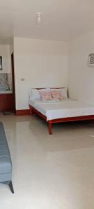 a bed sitting in a room with a white wall at Mangas Residents in El Nido