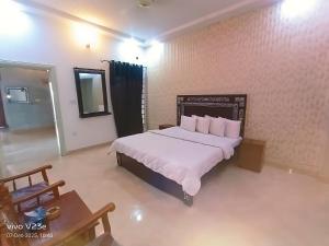a bedroom with a large bed and a table at Hotel Marvi Multan in Multan