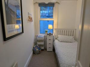 a small bedroom with a bed and a dresser and a window at Lough View in Rostrevor