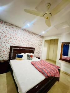 a bedroom with a large white bed with a ceiling at Hotel Marvi Multan in Multan