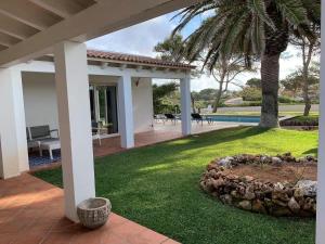 a house with a patio and a yard at Casa SONEA private access to Cala nBrut. in Cala en Blanes