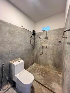 a bathroom with a toilet and a shower at La Cove in Matara