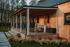 a screened in porch on the side of a house at Forrestia - osada turystyczna in Czaplinek