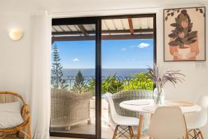 a patio with a table and chairs and a view of the ocean at Sunset View by JuMa in Rivière Noire
