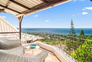 a balcony with chairs and a view of the ocean at Sunset View by JuMa in Rivière Noire