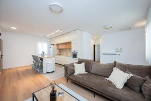 a living room with a couch and a kitchen at R26-Boutique in Zikhron Ya'akov