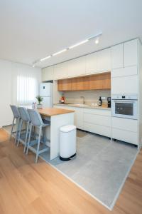 a kitchen with white cabinets and a table and chairs at R26-Boutique in Zikhron Ya'akov +13 photos