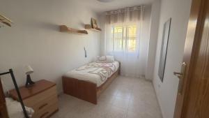 a small bedroom with a bed and a window at Tiburón Suite in Águilas