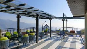 a patio with chairs and tables on top of a building at Maheshwari international in Lansdowne