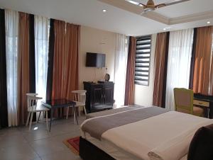a bedroom with a large bed and a desk and chairs at Maheshwari international in Lansdowne