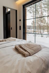 two beds with towels on them in front of a window at New Seaside Villa with Beach Sauna and Panoramic Views in Porvoo