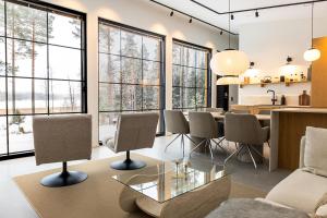 a living room with a table and chairs and windows at New Seaside Villa with Beach Sauna and Panoramic Views in Porvoo