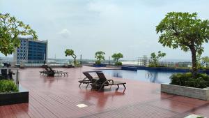 a patio with chairs and a pool on a building at SleepRest @ Pollux Habibie in Batam Center