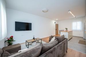 a living room with a couch and a tv on a wall at R26-Boutique in Zikhron Ya'akov