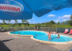 a group of people in a swimming pool at Le Bruant des Roseaux in Villegusien Le Lac