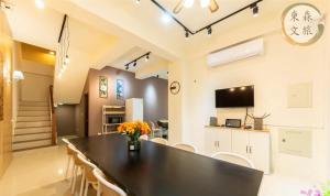 a kitchen and dining room with a black table and chairs at 不想回家民宿-免費停車-寵物友善-無門禁24小時進出-東森文旅-包棟優惠中 in Yuanshan