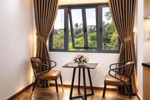 a table and two chairs in front of a window at B'lao Eco Lodge in Bảo Lộc