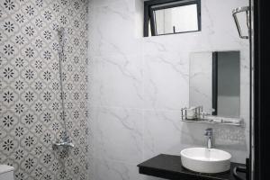 a white bathroom with a sink and a shower at B'lao Eco Lodge in Bảo Lộc