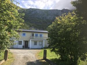 a large white house with a mountain in the background at House by Ramberg Beach in Ramberg +9 photos