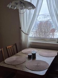 a table with three plates on it with a window at House by Ramberg Beach in Ramberg