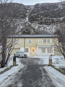 a car parked in front of a house in the snow at House by Ramberg Beach in Ramberg