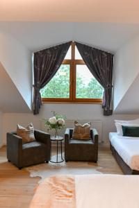 a bedroom with a bed and two chairs and a window at Hotel ZUM STERNENHOF in Kössen +97 photos