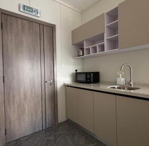 a small kitchen with a sink and a door at West14 Tamarin Bay,Studio in Tamarin +10 photos